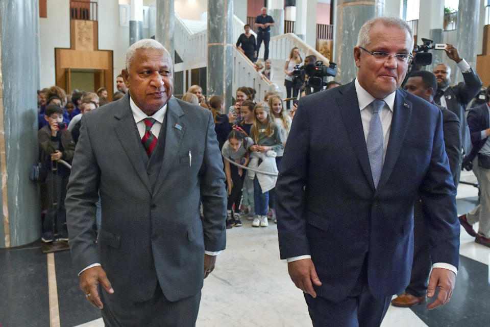 Australia's Prime Minister Scott Morrison, right, and Fiji's Prime Minister Voreqe Bainimarama walk through Parliament House after an official welcome ceremony in Canberra, Monday, Sept. 16, 2019. (Mick Tsikas/Pool via AP)