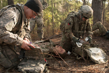 Sgt. Kyle Cabral, a combat medic with 3rd Battalion, 1st Security Force Assistance Brigade, advises an actor serving as a member of the Afghan National Army as they tend to a simulated soldier supposedly injured by a vehicle-born improvised explosive device along the route to their unit’s mission during training at the Joint Readiness Training Center at Fort Polk, Louisiana, U.S., January 23, 2018. Picture taken January 23, 2018. Spc. Noelle E. Wiehe, 50th Public Affairs Detachment, 3rd Infantry Division/U.S. Army/Handout via REUTERS