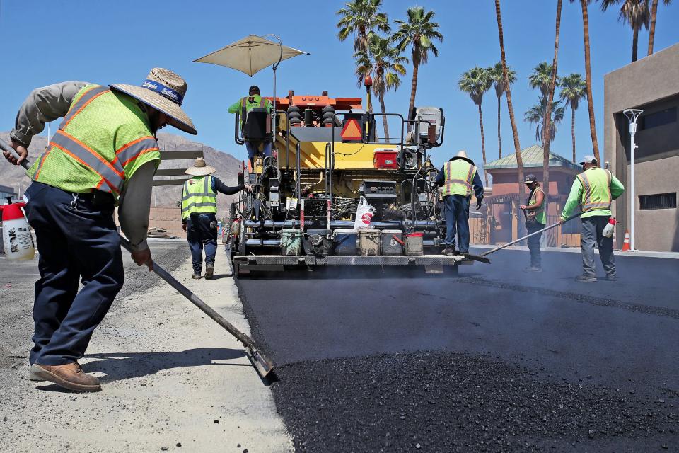 Ricardo Cazares of Hardy and Harper, Inc., works with fresh asphalt at the Presidents' Plaza parking lot in Palm Desert, Calif., on Wednesday, May 11, 2022.
