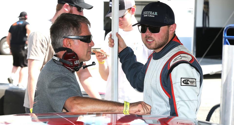 Layne Riggs (right) discusses adjustments to his car with his father, Scott Riggs (left) during a break in practice at a NASCAR Advance Auto Parts Weekly Series event in 2022 at South Boston Speedway. (Joe Chandler/South Boston Speedway)