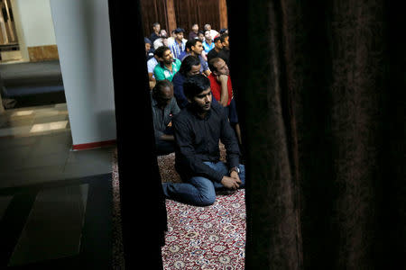 Muslim men attend Eid al-Fitr prayers at a makeshift mosque in a basement, to mark the end of the holy month of Ramadan, in Piraeus, near Athens, Greece July 6, 2016.REUTERS/Alkis Konstantinidis