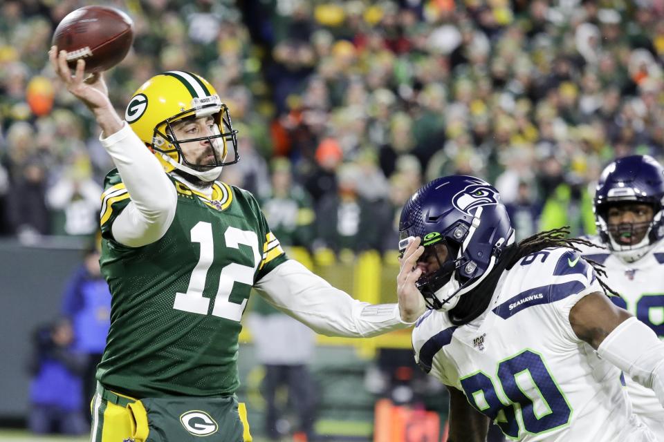 Green Bay Packers' Aaron Rodgers passes while being rushed by Seattle Seahawks' Jarran Reed during the first half of an NFL divisional playoff football game Sunday, Jan. 12, 2020, in Green Bay, Wis. (AP Photo/Darron Cummings)