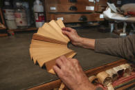 Anne Hoguet, 74, fan-maker and director of the hand fan-making museum unfolds a mounting fan in her workshop Wednesday, Jan. 20, 2021. Just like the leaves of its gilded fans, France's storied hand fan-making museum could fold up and vanish. The splendid Musee de l'Eventail in Paris, a classed historical monument, is the culture world's latest coronavirus victim. (AP Photo/Michel Euler)