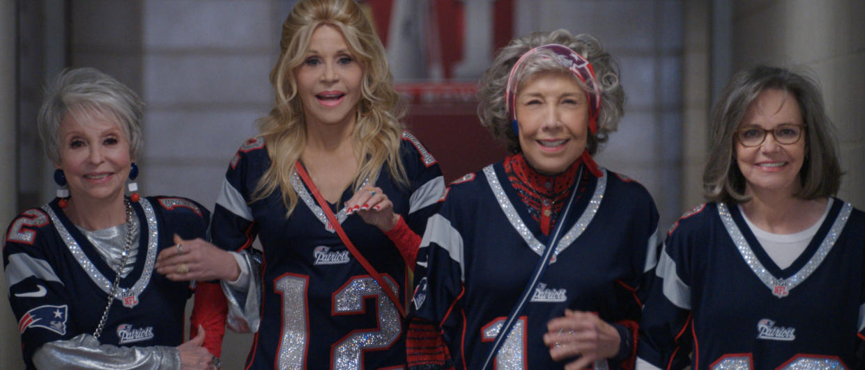  Rita Moreno, Jane Fonda, Lily Tomlin, and Sally Field walking together, while wearing Patriots jerseys, in 80 For Brady. 