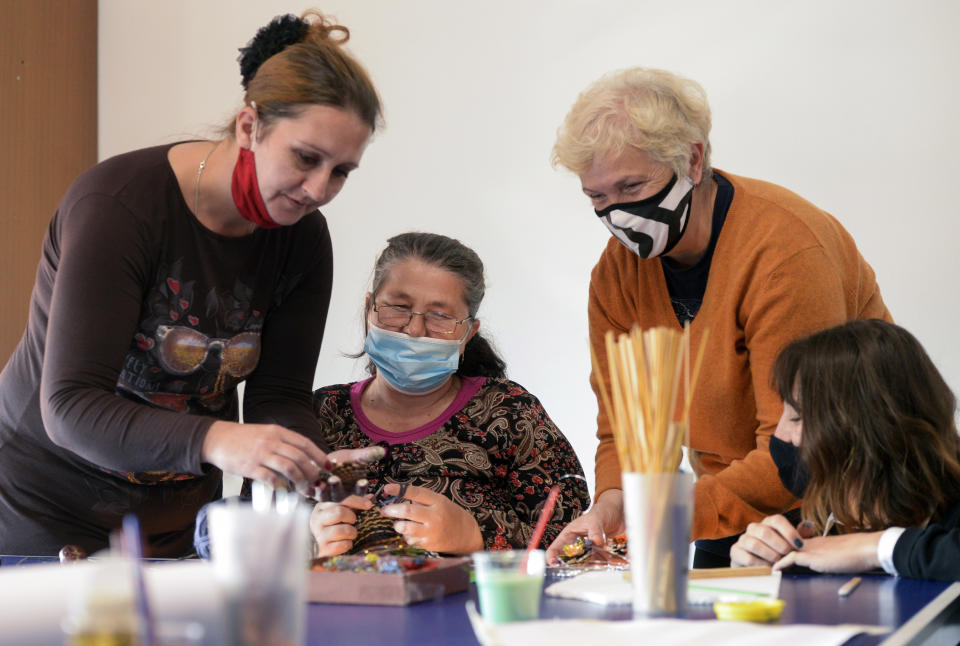 A a woman paints a pine cone during a therapy session in Sarajevo, Bosnia Monday, Oct. 26, 2020. As coronavirus cases surge in Bosnia, the pandemic is heaping new trouble on an impoverished nation that has never recovered economically or psychologically from a war in the 1990s. Bosnian health authorities estimate that nearly half of the Balkan nation’s nearly 3.5 million people have suffered some degree of trauma resulting from the war. (AP Photo/Kemal Softic)