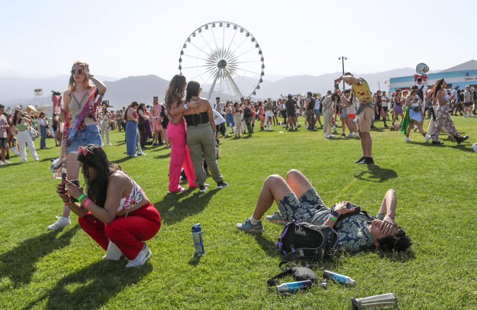 A festival-goer, right, succumbs to the heat at the Coachella Valley Music and Arts Festival in Indio, Calif., Friday, April 14, 2023.