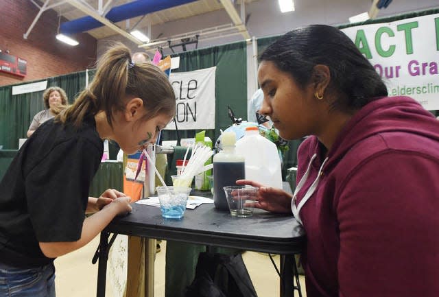 Ames Climate Action Team member and Ames High sophomore Shreya Reddy, right, demonstrates a simple experiment to Mckinley McCloud, 5, during an Ames Eco-Fair at Ames City Hall in 2019.