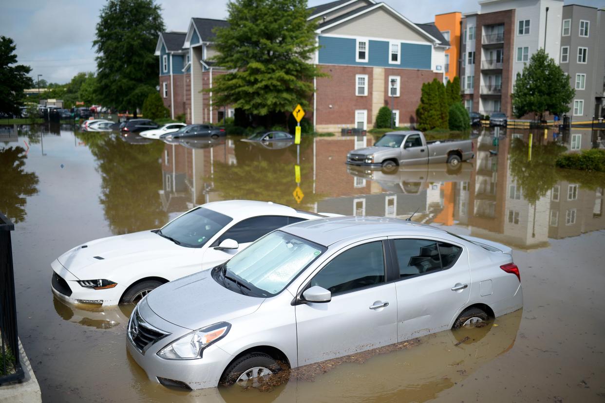 Cars are submerged in flood waters in a parking lot on 23rd Street between Grand and Forest avenues in Knoxville on Thursday.