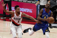 Portland Trail Blazers guard CJ McCollum, left, fouls Denver Nuggets forward Will Barton during the first half of an NBA basketball game in Portland, Ore., Wednesday, April 21, 2021. (AP Photo/Steve Dykes)