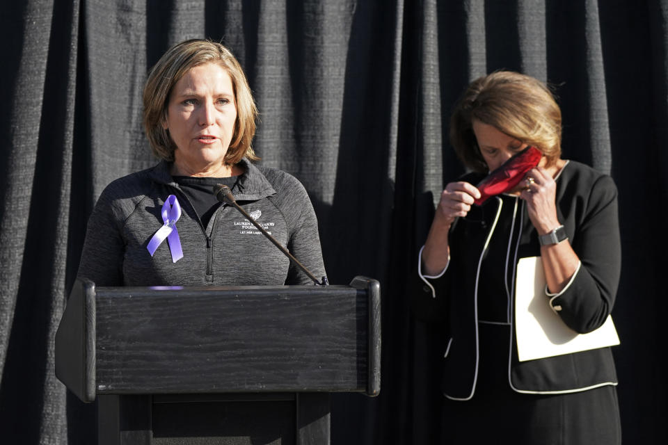 University of Utah President Ruth Watkins, right, puts on her mask as Jill McCluskey, the mother of slain University of Utah student-athlete Lauren McCluskey speaks during a press conference announcing they have reached a settlement in their lawsuit against the university Thursday, Oct. 22, 2020, in Salt Lake City. (AP Photo/Rick Bowmer)