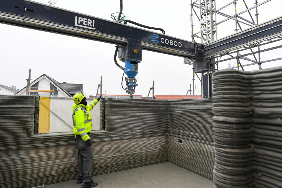 The wall of an apartment house is being printed by a 3D printer 