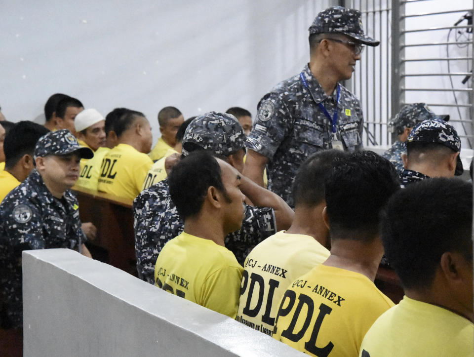 In this photo provided by the Supreme Court - Public Information Office, a crowd of accused sit at the trial venue inside a prison facility at Camp Bagong Diwa, Taguig city, Philippines, Thursday, Dec. 19, 2019. A Philippine court will rule Thursday whether scions of a political clan and their gunmen are guilty of slaughtering 58 people, including 32 media workers, in an act of impunity that horrified the world. (Supreme Court - Public Information Office via AP)