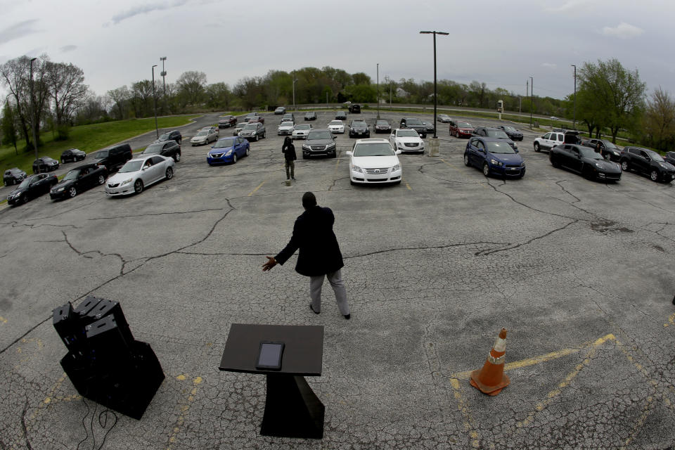 FILE - In this April 12, 2020 file photo, Pastor W.R. Starr II preaches during a drive-in Easter Sunday service while churchgoers listen from their cars in the parking lot at Faith City Christian Center in Kansas City, Kan. As the nation’s houses of worship weigh how and when to resume in-person gatherings while coronavirus stay-at-home orders ease in some areas, a new poll conducted April 30 - May 4, 2020 points to a partisan divide over whether restricting those services violates religious freedom. (AP Photo/Charlie Riedel, File)