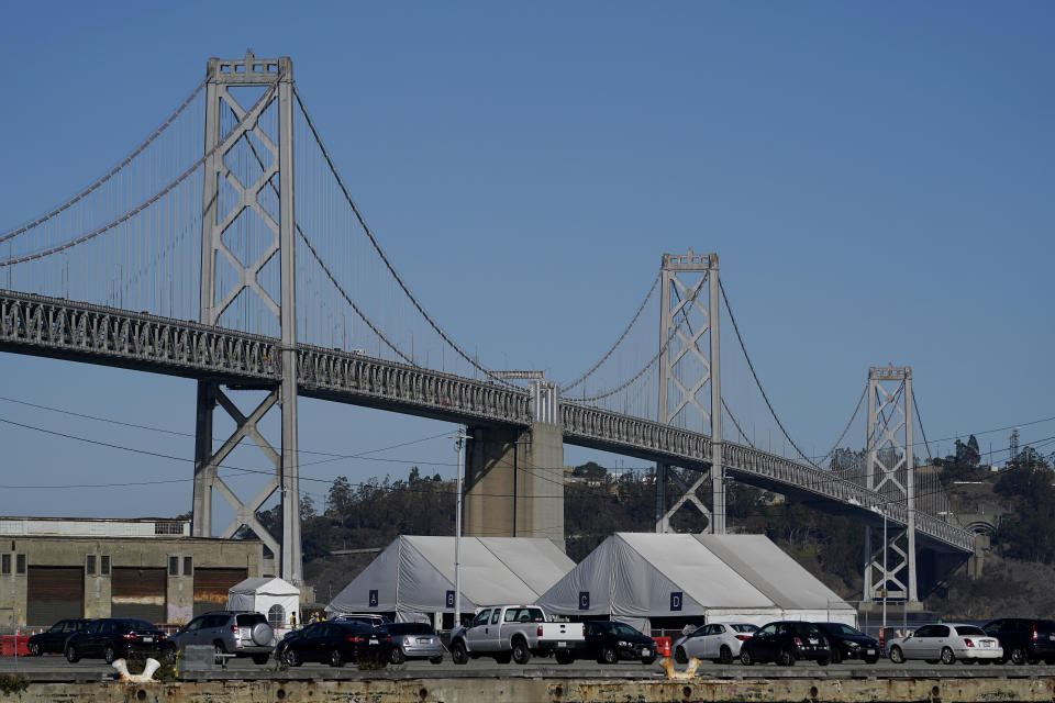 Tents from the CityTestSF at Pier 30/32 COVID-19 testing site sit in front of the San Francisco-Oakland Bay Bridge during the coronavirus pandemic in San Francisco, Wednesday, Dec. 23, 2020. (AP Photo/Jeff Chiu)