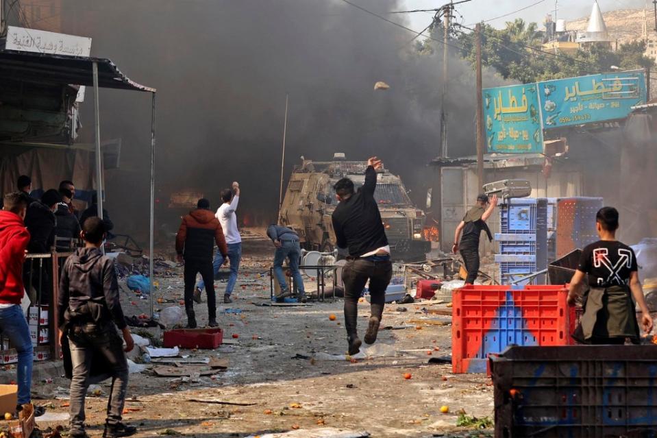 TOPSHOT - Palestinians clash with Israeli security forces during a raid in the occupied West Bank city of Nablus, on February 22, 2023. - Israeli troops killed nine Palestinians in a raid on Nablus, while some 80 more suffered gunshot wounds, the Palestinian health ministry said. (Photo by Zain Jaafar / AFP) (Photo by ZAIN JAAFAR/AFP via Getty Images)