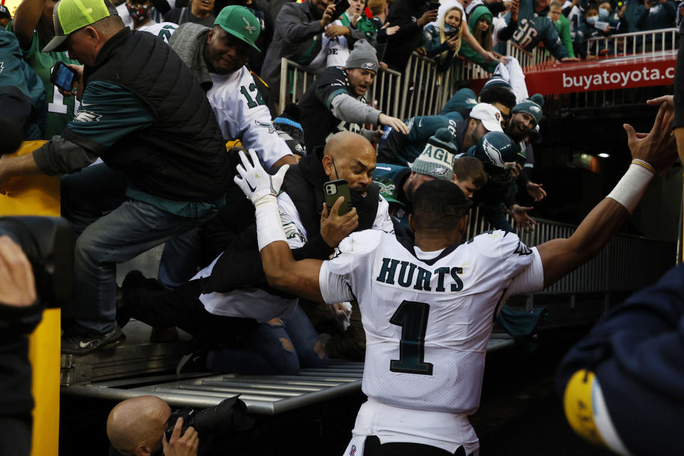 Jan 2, 2022; Landover, Maryland, USA; Fans fall from the stands after a railing gives way as Philadelphia Eagles quarterback Jalen Hurts (1) leaves the field after the Eagles&#39; game against the Washington Football Team at FedExField. Mandatory Credit: Geoff Burke-USA TODAY Sports