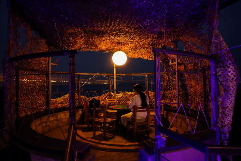 A woman enjoys the view at a former military bunker turned cafe on the coast in Kinmen