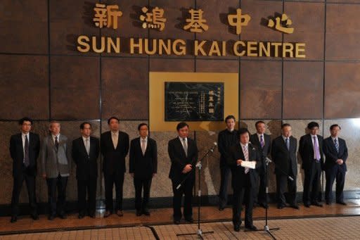 Chairman and Managing Director of Sun Hung Kai Properties Thomas Kwok (C-R), seen here making an announcement as co-Chairman and Managing Director of Raymond Kwok (C) looks on, in Hong Kong, on April 3. Hong Kong property tycoon brothers professed their innocence after they were arrested as part of the Asian financial hub's biggest corruption probe