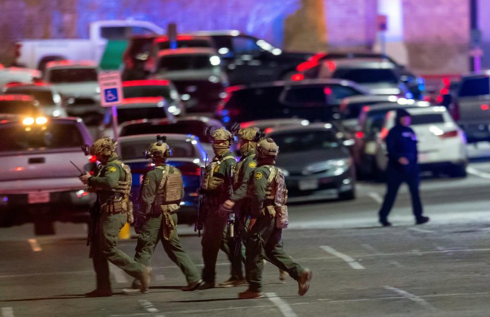 Law enforcement agents walk in the parking lot of a shopping mall, Wednesday, Feb. 15, 2023, in El Paso, Texas. Police say one person was killed and three other people were wounded in a shooting at Cielo Vista Mall. One person has been taken into custody, El Paso police spokesperson Sgt. Robert Gomez said.