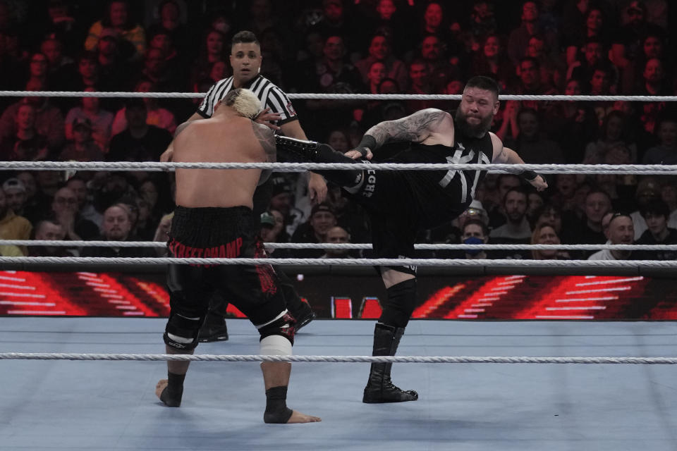 Wrestler Kevin Owens kicks Solo Sikoa during the WWE Monday Night RAW event, Monday, March 6, 2023, in Boston. WWE’s WrestleMania arrives this weekend, Saturday, April 1, to a massive audience and vastly larger advertising revenue as it seeks to establish itself as a serious contender for major advertising bucks. (AP Photo/Charles Krupa)