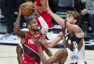 Portland Trail Blazers guard Damian Lillard, left, drives to the basket toward Indiana Pacers forward Domantas Sabonis, right, and center Myles Turner, center, during the second half of an NBA basketball game in Portland, Ore., Thursday, Jan. 14, 2021. (AP Photo/Craig Mitchelldyer)