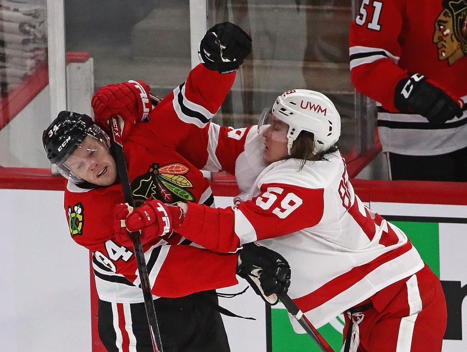 Carl Soderberg (34) of the Chicago Blackhawks and Tyler Bertuzzi (59) of the Detroit Red Wings get into a shoving match in front of the Blackhawks bench at the United Center on Jan. 24, 2021, in Chicago