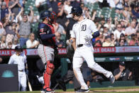 Detroit Tigers' Mark Canha, right, scores as Minnesota Twins catcher Christian Vázquez looks on in the eighth inning of a baseball game, Sunday, April 14, 2024, in Detroit. (AP Photo/Paul Sancya)