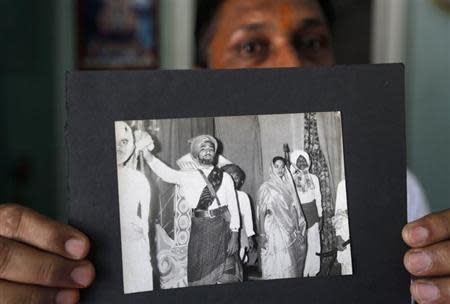 Head teacher A.R. Goswami shows an old photograph of Narendra Modi (2nd L), prime ministerial candidate for Bharatiya Janata Party (BJP), taking part in a play at a school in Vadnagar in Gujarat March 26, 2014. REUTERS/Amit Dave