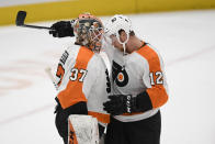 Philadelphia Flyers goaltender Brian Elliott (37) and left wing Michael Raffl (12) celebrate after the team's NHL hockey game against the Washington Capitals, Wednesday, March 4, 2020, in Washington. The Flyers won 5-2. (AP Photo/Nick Wass)