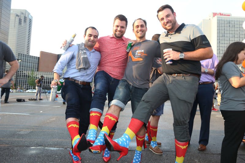 Men wearing high heels show off their shoes and colorful socks before participating in the YWCA's Walk a Mile in Their Shoes in St. Louis on August 3. On February 10, 1870, the Young Women's Christian Association was founded in New York. File Photo by Bill Greenblatt/UPI