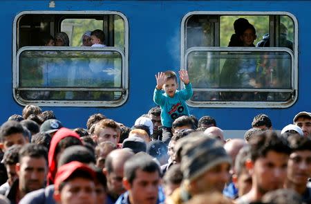 A boy reacts as migrants walk towards Austria from the train station in Hegyeshalom, Hungary , September 23, 2015. REUTERS/Leonhard Foeger