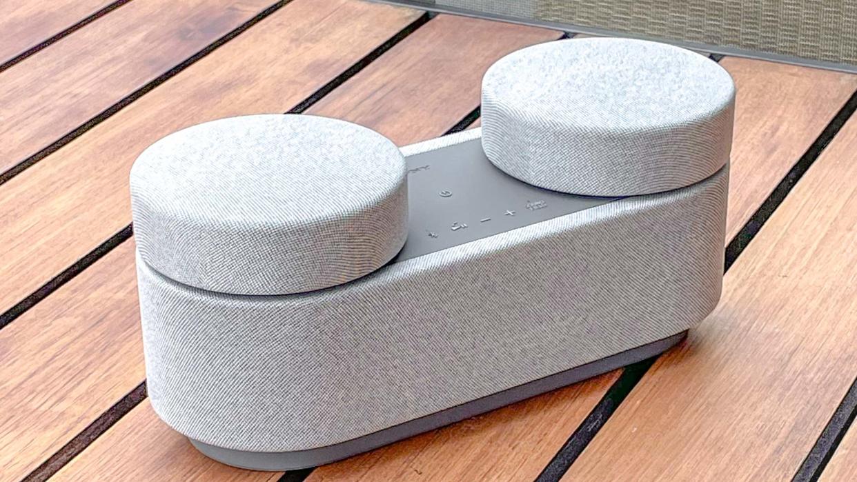  Listing image of Sony HT-AX7 speaker system placed on a table outside. 