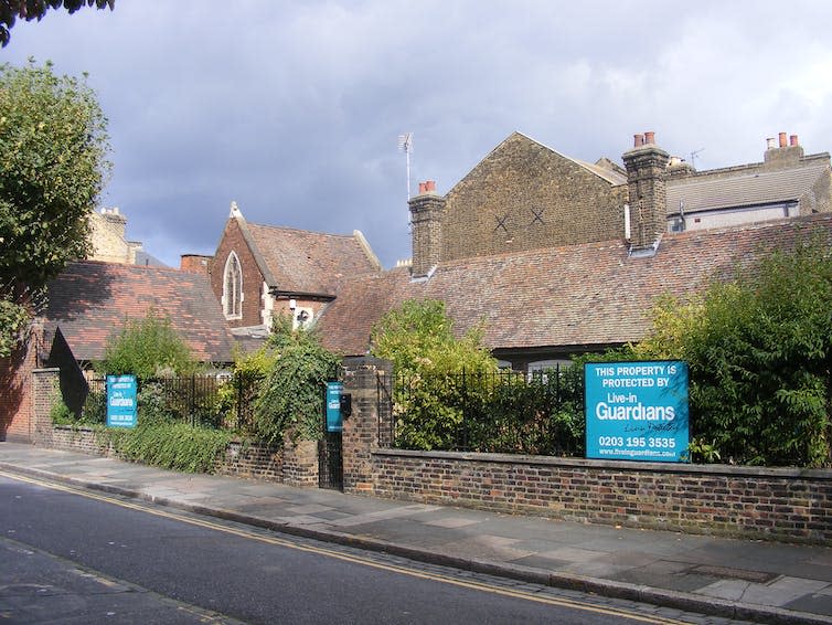 A blue sign in a garden.