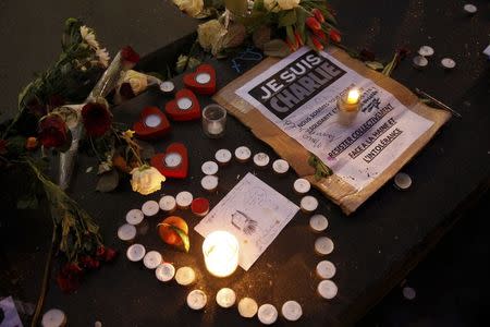 Candles form a heart, near a placard with the message, "I am Charlie" as people continue to pay tribute to the shooting victims on Wednesday at the satirical weekly Charlie Hebdo, at the Republique square in Paris January 10, 2015. REUTERS/Pascal Rossignol