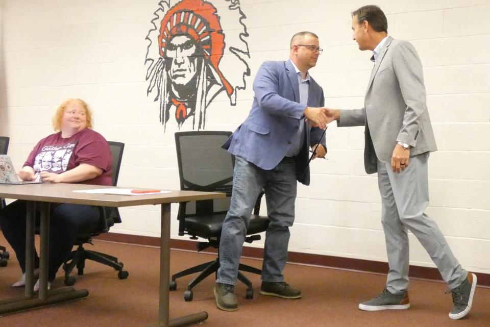 Scott Brown, regional liaison for Ohio Auditor of State Keith Faber, right, shakes the hand of Ryan Cook, Bucyrus City School District’s chief financial officer and director of operations, after presenting a commendation during Thursday night’s regular meeting of the district’s board of education. Board member Jenna Bollinger is at left.