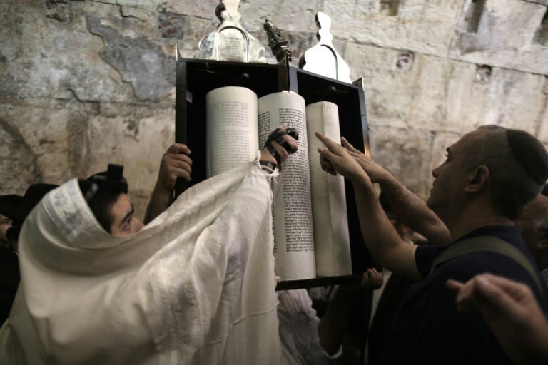 Orthodox Jewish men read the Torah during prayers at the Western Wall to mark the annual Tisha B'Av (Ninth of Av) day of fasting and memorial on August 14, 2016