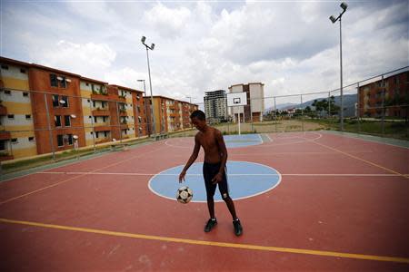 A boy plays with a ball in Ciudad Caribia outside Caracas September 19, 2013. REUTERS/Jorge Silva