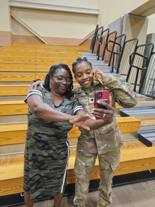 This undated image provided by Shawn Sanders shows Army Spc. Kennedy Sanders, right, posing for a selfie with her mother, Oneida Oliver-Sanders, at a ceremony in Columbus, Ga., on Aug. 9, 2023. The 24-year-old Army reservist's parents confirmed she was among three U.S. service members killed Sunday, Jan. 28, 2024, by a drone strike at their base in Jordan near the border with Syria. Sanders of Waycross, Georgia, joined the Army Reserve five years ago, her parents said, and was taking college courses to become an X-ray technician. (Shawn Sanders via AP)