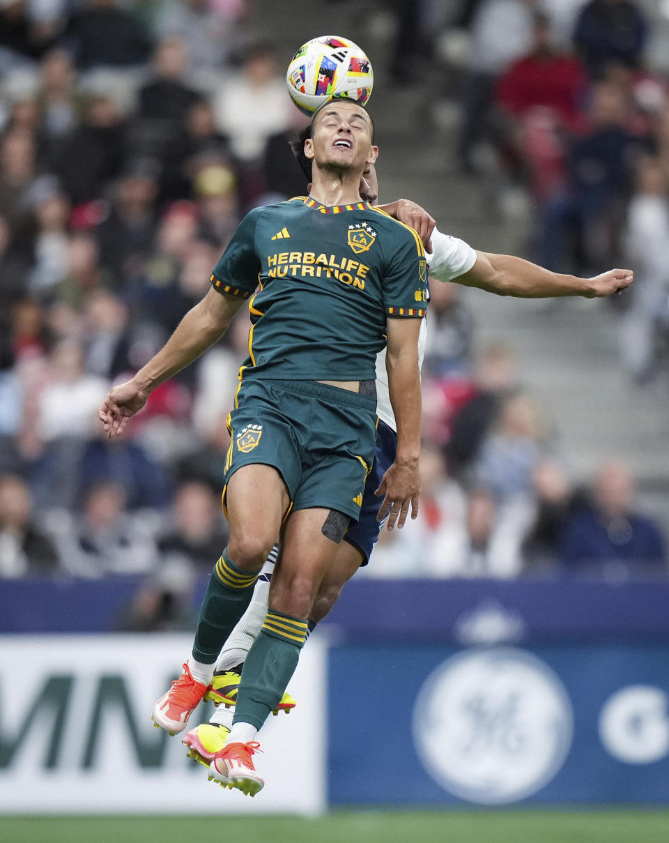 LA Galaxy's Dejan Joveljic, front, and Vancouver Whitecaps' Mathias Laborda go up for a head ball during the second half of an MLS soccer match Saturday, April 13, 2024, in Vancouver, British Columbia. (Darryl Dyck/The Canadian Press via AP)