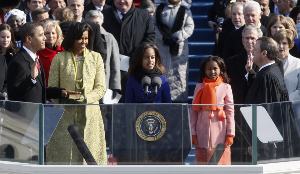 FILE - In this Jan. 20, 2009 file photo, Barack Obama, left, joined by his wife, Michelle, second from left, and daughters Malia, third from left, and Sasha, takes the oath of office from Chief Justice John Roberts to become the 44th president of the United States at the U.S. Capitol in Washington. Obama will raise his right hand and place his left on a Bible as he takes the oath of office for a second four-year term. His second inauguration promises the pageantry of the first, but on a smaller scale than 2009, when a record 1.8 million people filled the nation's capital to witness Obama making history as America's first black president. (AP Photo/Ron Edmonds, File)