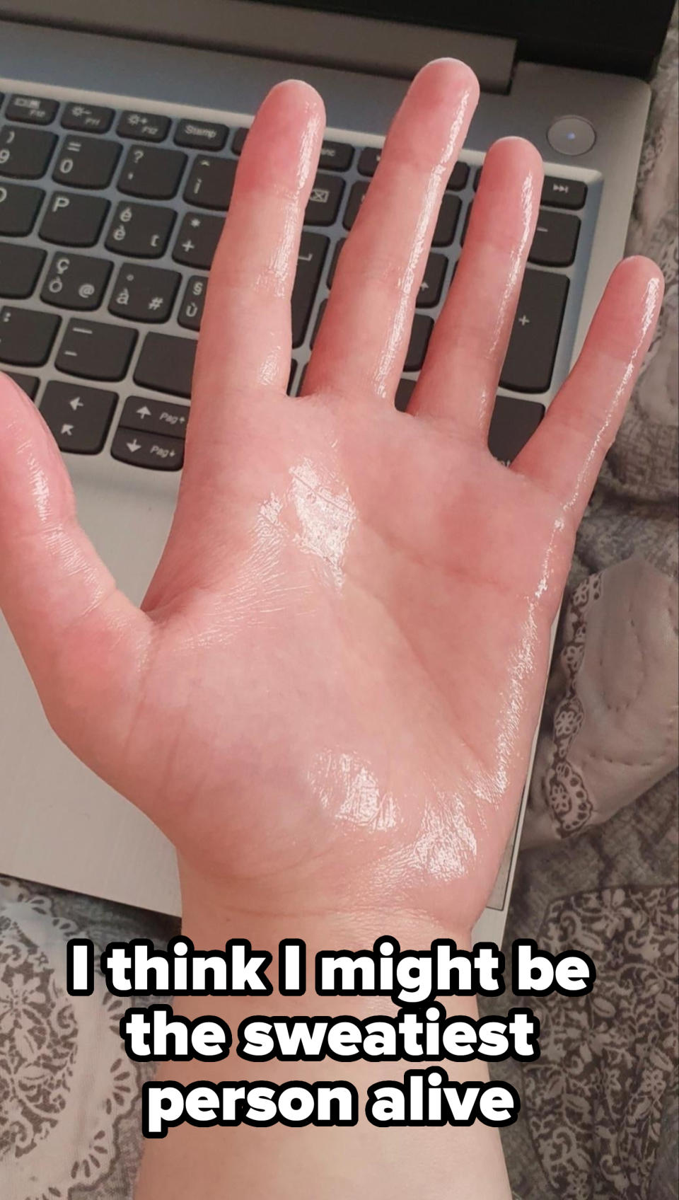 A hand appears greasy or wet, hovering over a keyboard, suggesting a possible spill or unusual use of a product