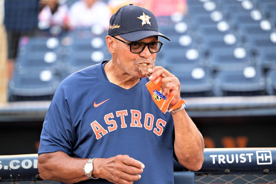 In response to the question, "Reggie, are you hungry?" Jackson smiles and takes a bite from his feature "Reggie" candy bar before throwing the ceremonial first pitch at Ballpark of the Palm Beaches (Mar. 18, 2023).