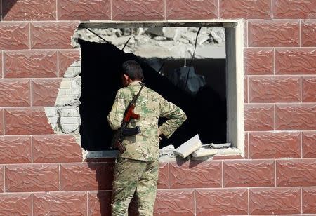 A Sunni Arab fighter looks at a house which belonged to a Islamic State militant, in Rfaila village in the south of Mosul, Iraq, February 17, 2017. Picture taken February 17, 2017. REUTERS/Khalid al Mousily