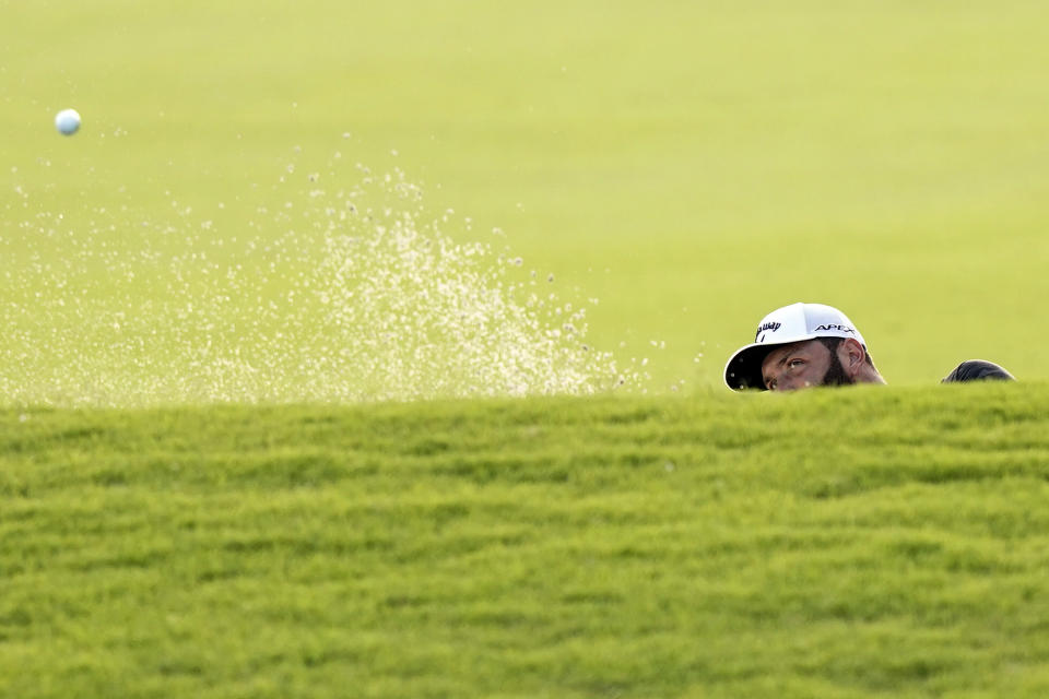 Jon Rahm, of Spain, hits from a bunker on the 18th hole during the third round of the Tour Championship golf tournament Saturday, Sept. 4, 2021, at East Lake Golf Club in Atlanta. (AP Photo/Brynn Anderson)