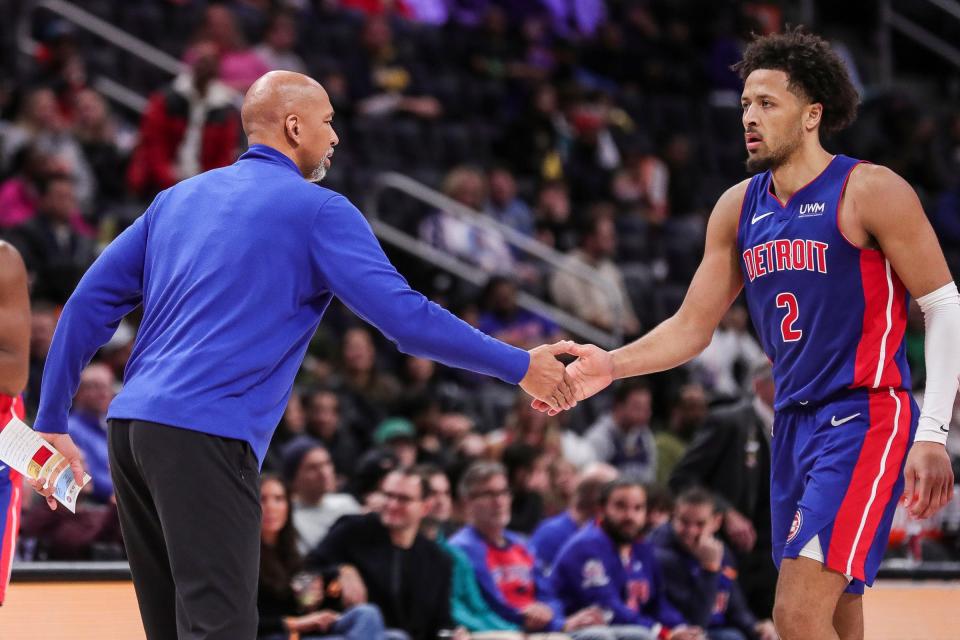 Monty Williams shakes hands with Cade Cunningham, right, at a timeout during the Pistons' 18th straight loss Wednesday to the Memphis Grizzlies at near-empty Little Caesars Arena.