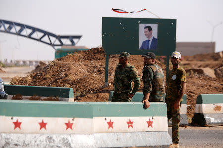 FILE PHOTO: Syrian soldiers stand at the Nasib border crossing with Jordan in Deraa, Syria July 7, 2018. REUTERS/ Omar Sanadiki/File Photo