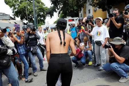 A woman is surrounded by the media as she argues with the police during a women's march to protest against President Nicolas Maduro's government in Caracas, Venezuela, May 6, 2017. REUTERS/Carlos Garcia Rawlins