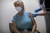 Yvette Pau, 56, receives the second dose of the Pfizer-BioNTech COVID-19 vaccine, in Gibraltar, Thursday, March 4, 2021. Gibraltar, a densely populated narrow peninsula at the mouth of the Mediterranean Sea, is emerging from a two-month lockdown with the help of a successful vaccination rollout. The British overseas territory is currently on track to complete by the end of March the vaccination of both its residents over age 16 and its vast imported workforce. But the recent easing of restrictions, in what authorities have christened “Operation Freedom,” leaves Gibraltar with the challenge of reopening to a globalized world with unequal access to coronavirus jabs. (AP Photo/Bernat Armangue)