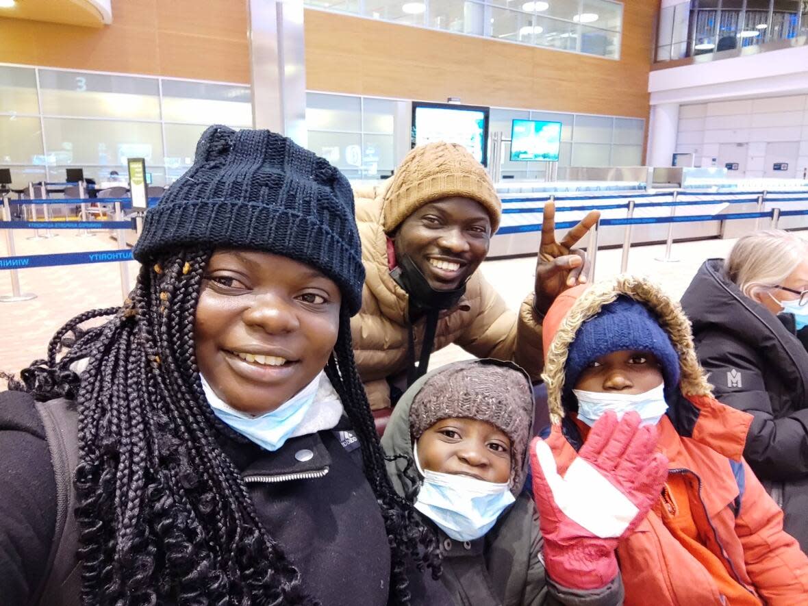 Oluwaseun Adewolu, left, poses with her two children after landing in Canada at Winnipeg Richardson International Airport in March. Her brother, top right, came to greet them after not seeing the family for two years. (Oluwaseun Adewolu - image credit)
