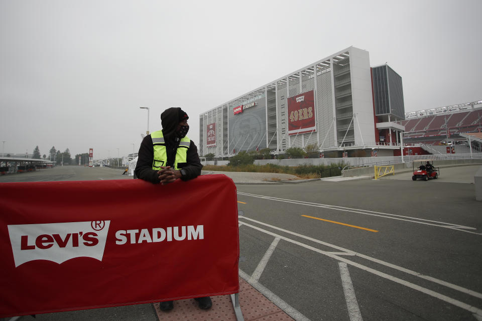 FILE - In this Sept. 13, 2020, file photo, a worker stands outside of Levi's Stadium before an NFL football game between the San Francisco 49ers and the Arizona Cardinals in Santa Clara, Calif. California officials ramped up more mass coronavirus vaccination sites Friday, Feb. 5, 2021, amid a critical supply shortage, with one San Francisco Bay Area county announcing a mega-site capable of 15,000 shots a day even as another said it stopped first doses to ration enough for those needing their second inoculation. Santa Clara County and the 49ers said they will open California's largest vaccination site at Levi's Stadium early next week, eventually capable of injecting up to 15,000 people each day as supplies allow. (AP Photo/Josie Lepe, File)